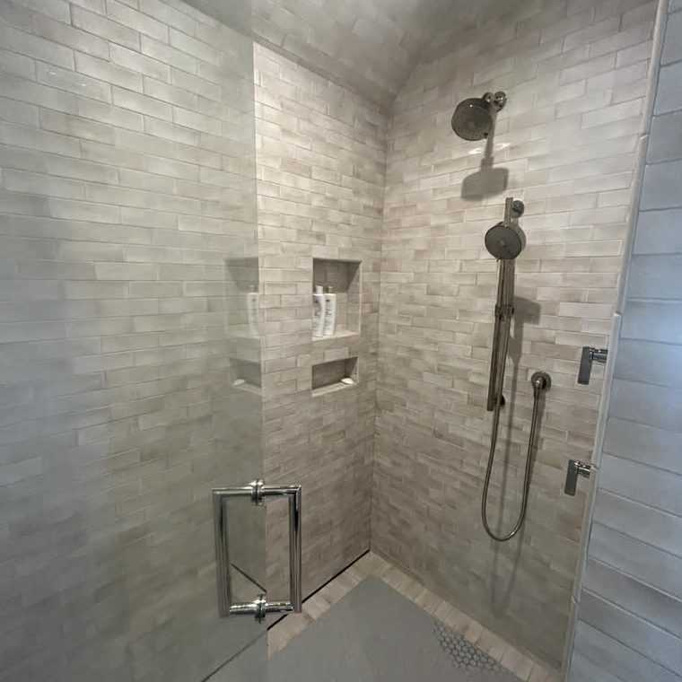 Walk-in tile shower with rain head and handheld sprayer installed by KW Plumbing